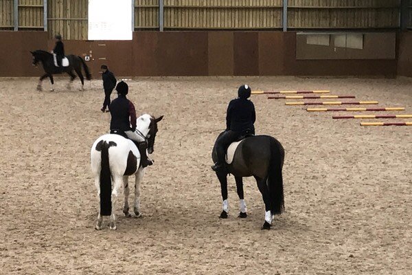 Riders practicing inside indoor arena