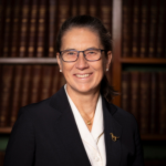 Headshot of Elspeth Talbot Rice KC, World Horse Welfare trustee wearing a white blouse and a black jacket with a bookcase in the background.